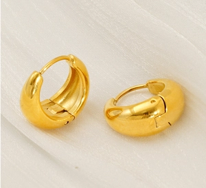 Dettaglio degli orecchini a cerchio spessi in acciaio inossidabile placcato oro 18k su tessuto