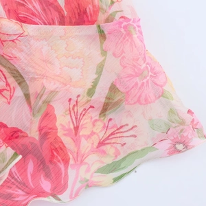 Detail von leichtem Chiffonstoff mit rosa Blumendruck und gewelltem Saumabschluss