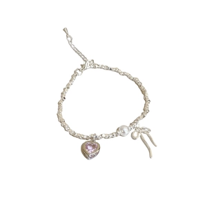 Silver beaded necklace featuring a pink heart zircon, a pearl, and a metallic bow pendant