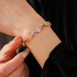 Detailed close-up of oval rainbow gemstones with diamond halo on golden vintage bracelet