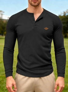 Detail of waffle-knit texture and buttoned Henley collar on this black long-sleeve men's shirt