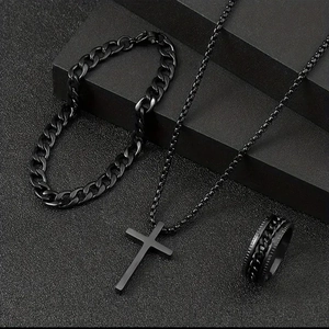 Détail d'un ensemble de bijoux noirs en acier inoxydable avec collier croix et bague