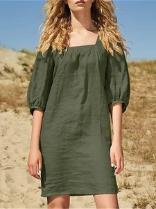 Detailed texture of green linen cotton square neck dress on a model outdoors