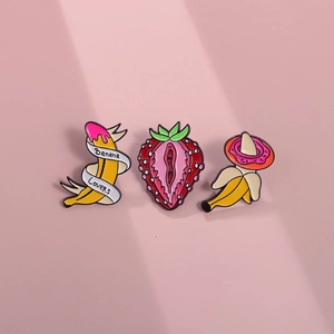 Creative fruit alloy brooches featuring banana and strawberry designs on pink background