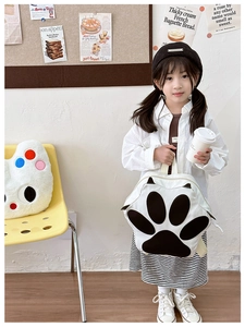 Cute Japanese style backpack with cat paw print shown on a little girl in a cozy room