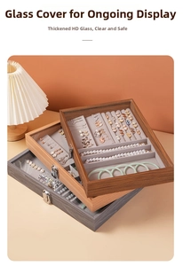 Macro shot of tiered walnut wood jewelry organizers with clear glass lids and velvet lining