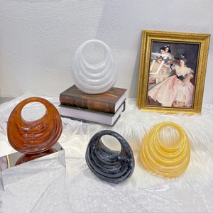 Detail showing acrylic evening bags in wavy oval design with tortoiseshell and marble patterns