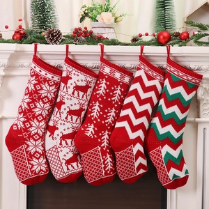 Set of 5 knitted Christmas stockings with snowflake and reindeer patterns on a mantel