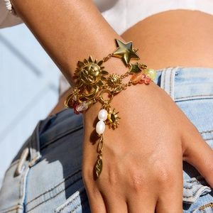 Layered gold star and moon celestial bracelet with pearls and colorful beads on wrist