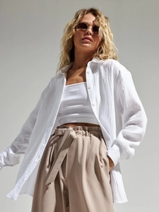 Detail of white cotton crepe shirt and high-waist wide-leg trousers for women set