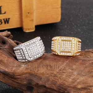 Macro shot of gold and silver hip hop rings with cubic zirconia pavé on a wood base