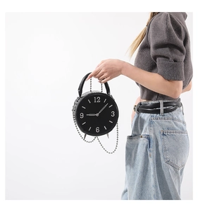 Detail of unique clock-shaped round crossbody bag with silver chain and white numerals