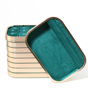 Detail view of emerald green velvet jewelry tray with gold metal trim and ring slots