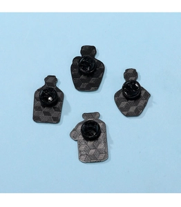 Detail of four metal pin backs with butterfly clutches on a light blue background