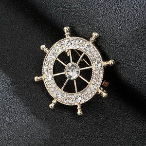 Golden ship wheel lapel pin for men with sparkling white crystals on black leather