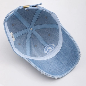 Detail der Innenseite einer hellblauen Jeans-Baseballkappe mit Vintage-Metallschnalle