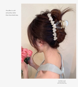 Elegant jelly hair claw clip with pearlescent white hearts on a sophisticated updo