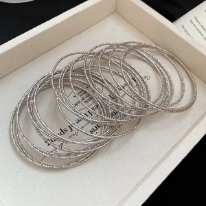 Detail of silver multi-ring bangle set with textured stars engraving on jewelry display