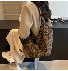 Detail of leopard print tote bag with black handles and Fashion Bag label