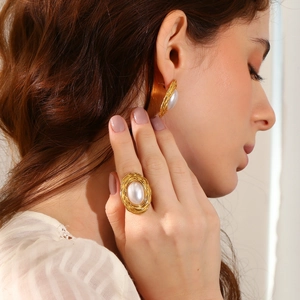 Detail of 18K gold-plated flower ring and earrings set with white pearls on model