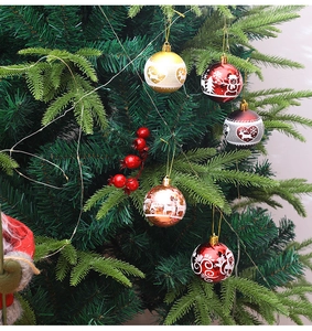 Close-up of painted Christmas balls with reindeer and snowflake patterns on a tree