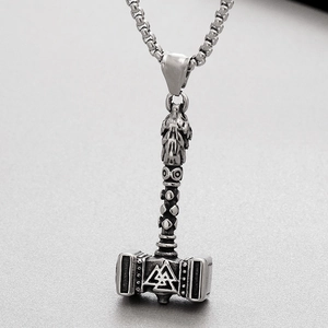 Macro detail of silver Thor's Hammer pendant with wolf head and Valknut symbol