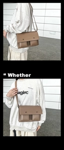 Detail view of taupe leather messenger bag with double front pockets and adjustable strap