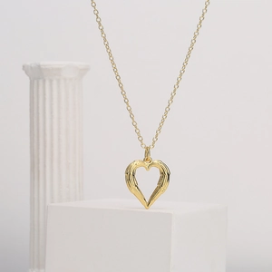 18K gold plated heart angel wing necklace for women on white geometric stand