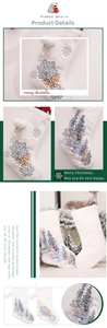 Detail of white plush Christmas stocking featuring blue tree and snowflake embroidery