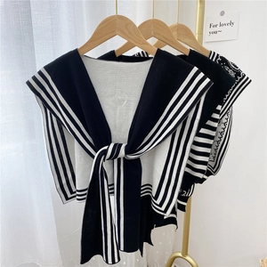 Knit shawl with black and white stripes and paisley patterns featuring a large front bow