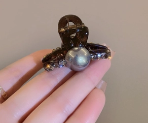Close-up of tortoise shell hair claw clip with silver beads and rhinestone accents