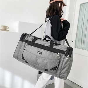 Detailed view of grey waterproof nylon travel bag featuring reinforced black handles