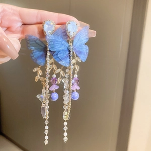 Detail of blue tulle butterfly earrings with tassel fringes, crystals and pearls