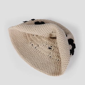 Texture détaillée d'un chapeau cloche en crochet beige fait main à motifs floraux