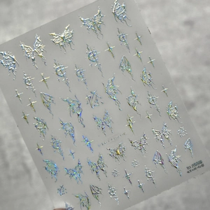 Dettaglio macro di adesivi olografici per unghie con farfalle, kanji e stelle lucenti