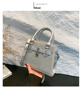 Detail of silver square handbag with sparkling rhinestones and metal buckle lock