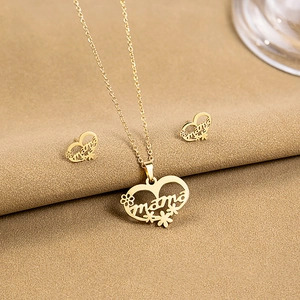 Close-up of golden heart-shaped necklace and earrings set with mama floral engraving