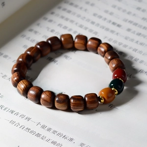 Macro shot of sandalwood beads on book page showing natural grain and colorful accents