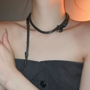 Macro detail of dark grey mesh snake choker with deep blue sparkling crystal accents