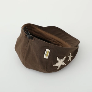 Close-up of brown beret featuring star patch, adjustable drawstring and brand label