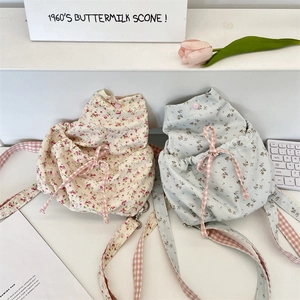 Detail of floral canvas backpacks with drawstring closure and plaid shoulder straps