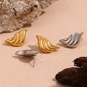 Detailed view of striped liquid waterdrop earrings in gold and silver finish on natural stone
