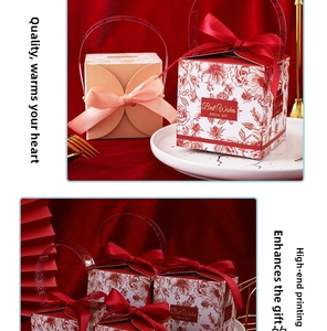 Detail of floral wedding candy boxes with gold foil text, ribbons, and PVC handles