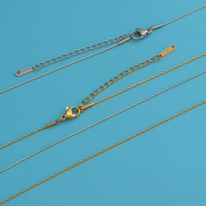 Detailed view of gold and silver stainless steel chains with lobster clasps and S.STEEL tags