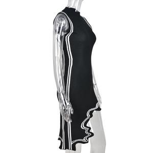 Detalle de vestido negro de punto sin mangas con rayas blancas y dobladillo asimétrico
