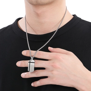 Detail of silver stainless steel cross pendant necklace on male model with black t-shirt