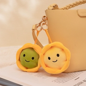 Pendentifs tartes aux œufs en peluche vert et jaune sur un sac à main en cuir beige