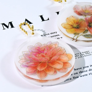Nahaufnahme von rundem Blumen-Acrylanhänger mit Goldrand und passender Perlenkette