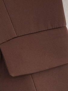 Close-up of the pocket flap on a brown woven suit jacket showing premium stitching