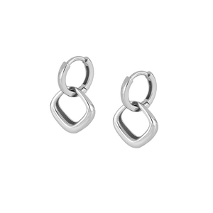 Macro shot of silver square geometric drop earrings with a brushed metallic texture